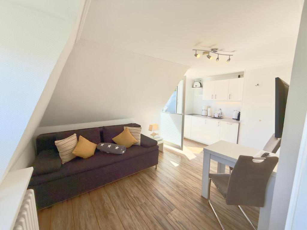 a living room with a couch and a table at Westerheide 51, App 1 in Wenningstedt