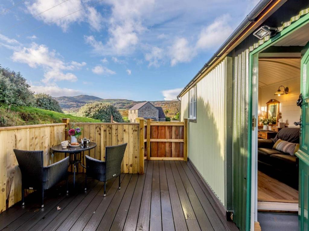 a deck with a bed and a table and chairs at 1 Bed in Conwy oc-79464 in Conwy