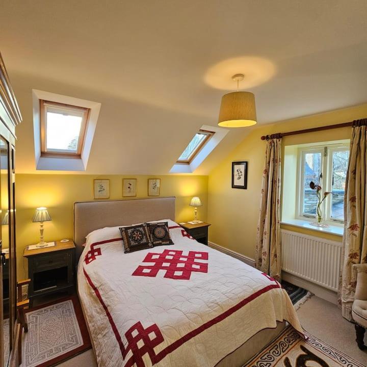 a bedroom with a large bed and two windows at Talbot Lodge BnB - Two ensuite bedrooms, near Bicester in Middleton Stoney
