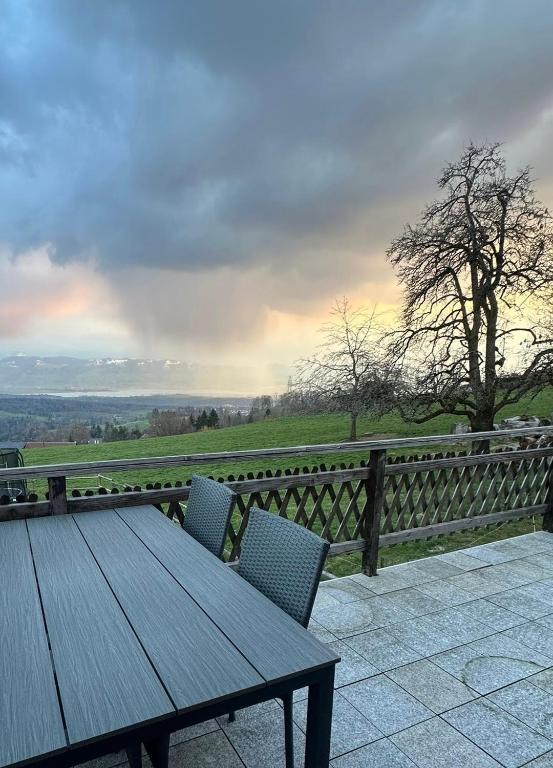 a wooden table and chairs on top of a fence at Panorama-Chalet Unterbach in Hinwil