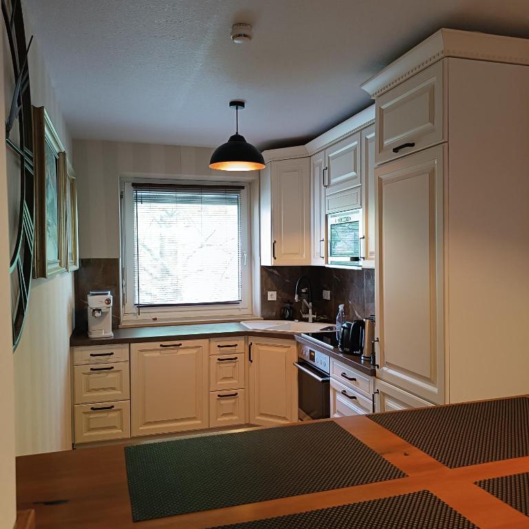 a kitchen with white cabinets and a window at Brilliant Home Messe in Nuremberg