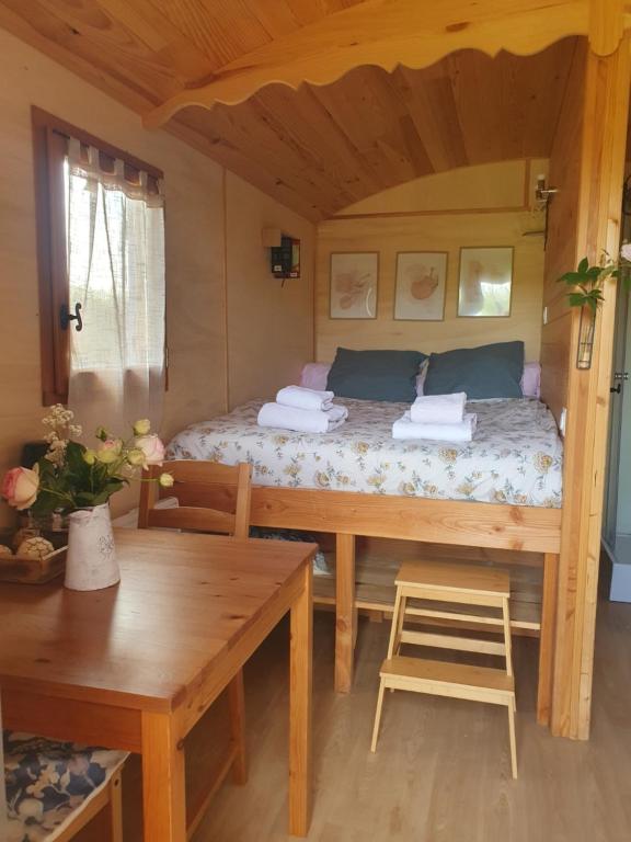 a bedroom with a bed in a wooden room at Roulotte bohème in Chazelles