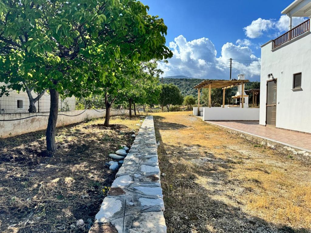 a garden with a tree and a stone path at Limnes Seaside Combo in Ligaridia