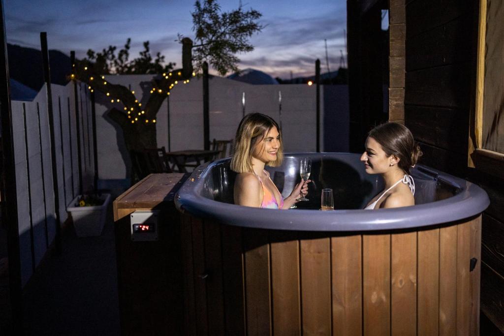 two women in a jacuzzi tub at night at Cabaña con jacuzzi privado in Caravaca de la Cruz