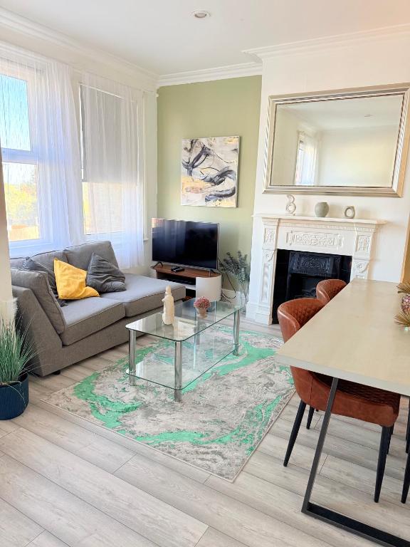 a living room with a couch and a fireplace at Large 3 bed 2 bath modern apartment in Finchley