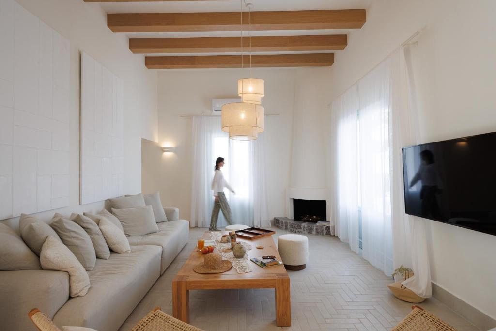 a living room with a couch and a person standing in the window at Eos Milos House in Pollonia