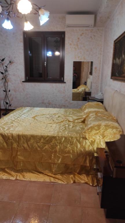 ein Schlafzimmer mit einem großen Bett und einer gelben Decke in der Unterkunft WINTAGE in Marino