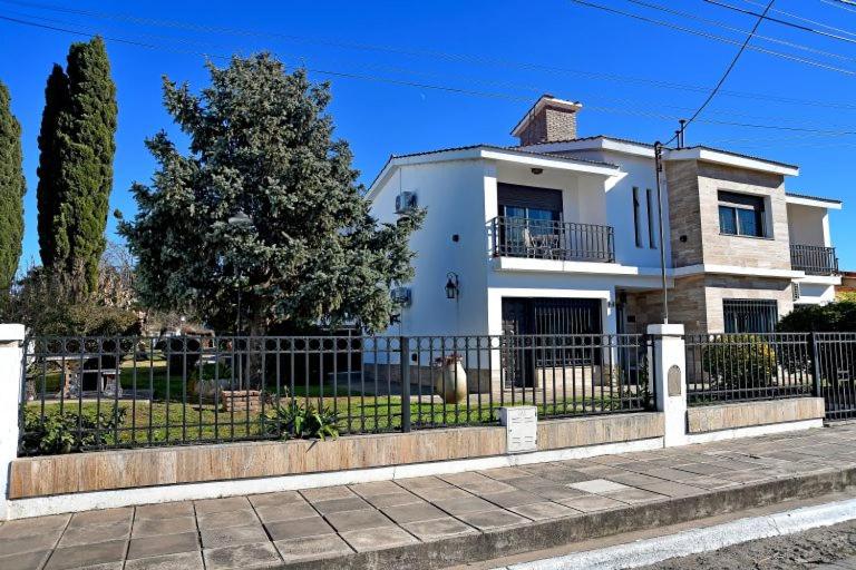 a white house with a fence in front of it at Residencial Garcia in Embalse
