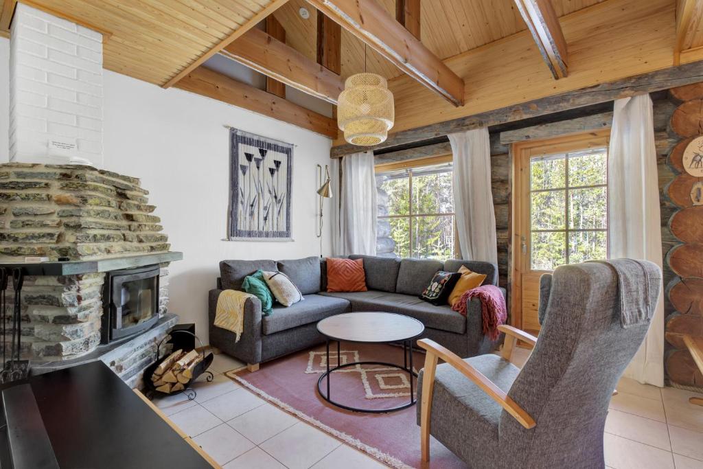 a living room with a couch and a fireplace at ÄkäsLuppo - Valkea Homes in Kittilä