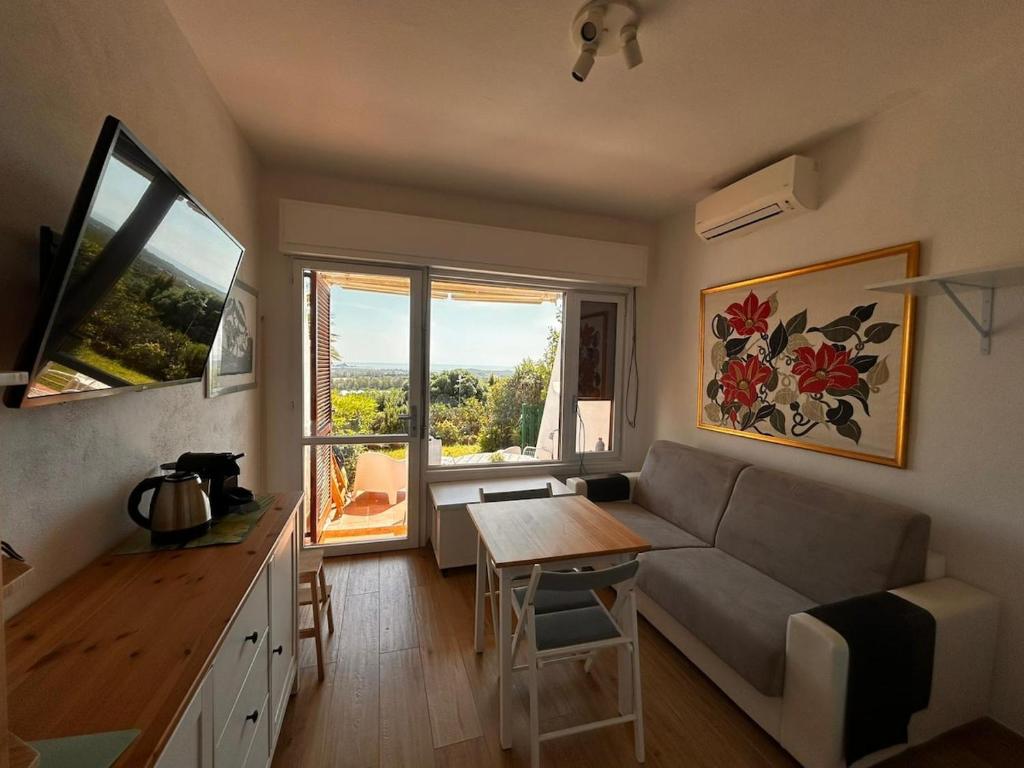 a living room with a couch and a table at Bilocale Is Molas Design, Giardino e Relax in Is Molas 