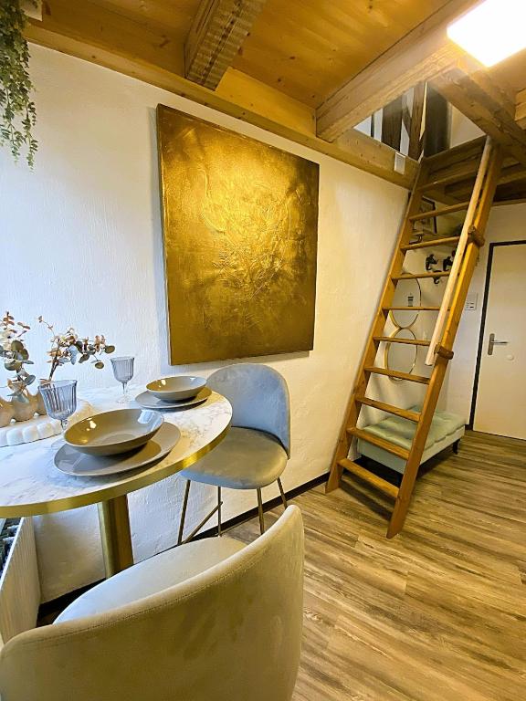 a dining room with a table and chairs and a staircase at Zentrales Design Loft über den Dächern St Gallens in St. Gallen