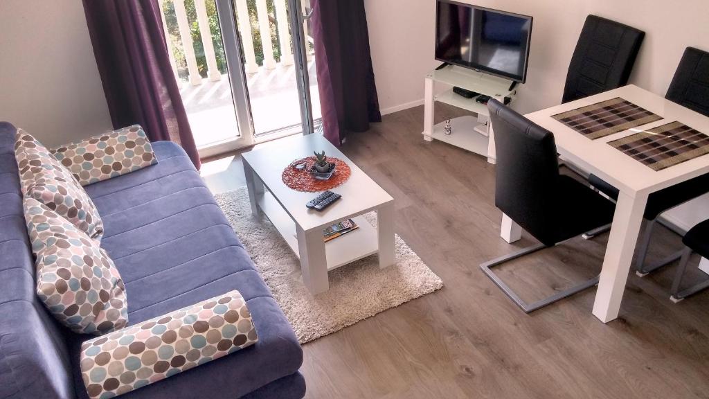 een woonkamer met een blauwe bank en een tafel bij Apartments Mila Tivat in Tivat