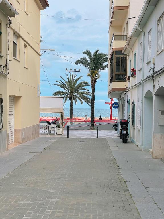 an empty street with palm trees on the beach at Casa junto al mar in Vinarós
