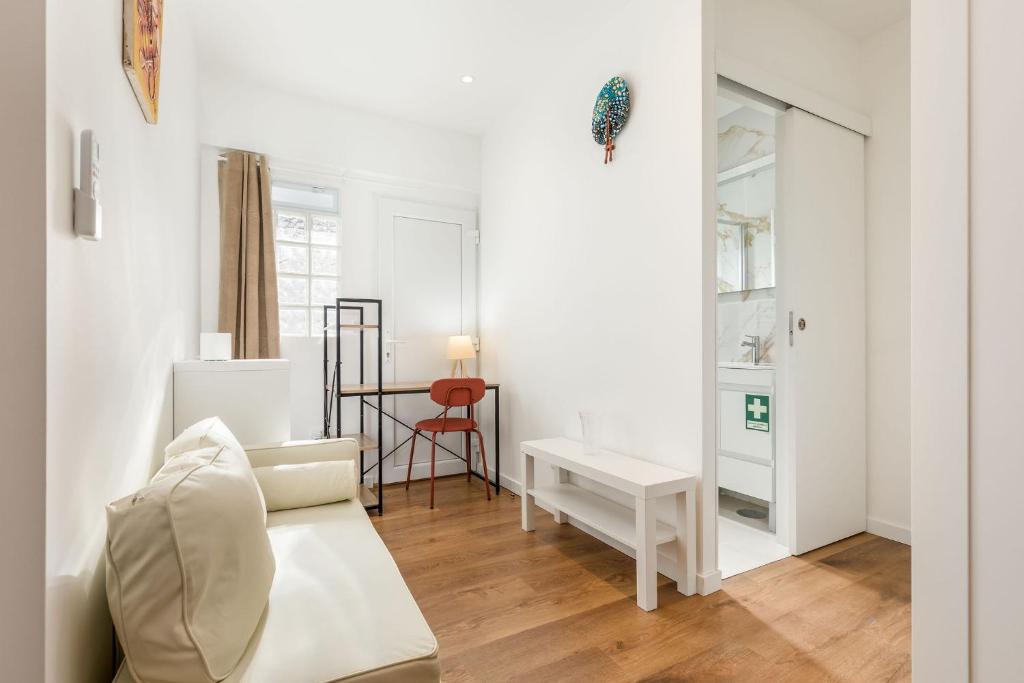 a white living room with a white couch and a table at Learn Fun Madalena - Shared Swimming pool in Madalena