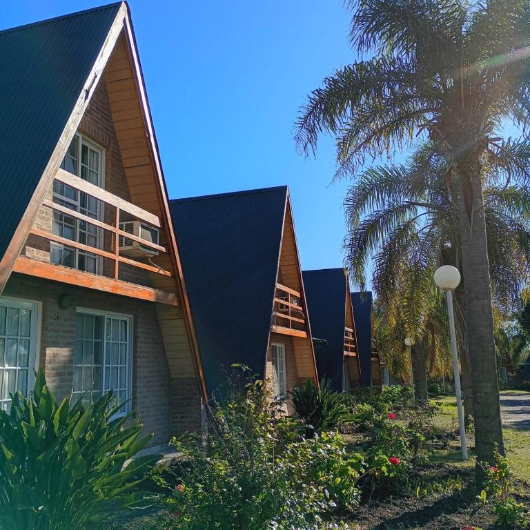 a house with a black roof and palm trees at Cabañas LAS PALMERAS in La Paz