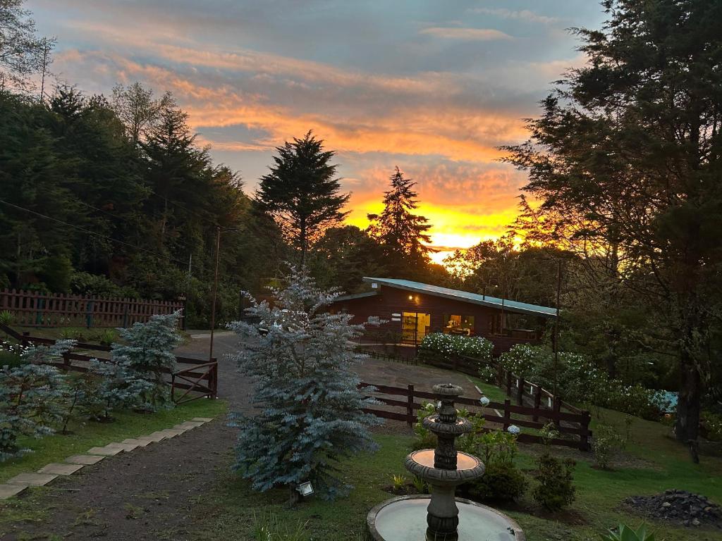 a fire hydrant in front of a house with a sunset at Curuba Lodge in El Copey