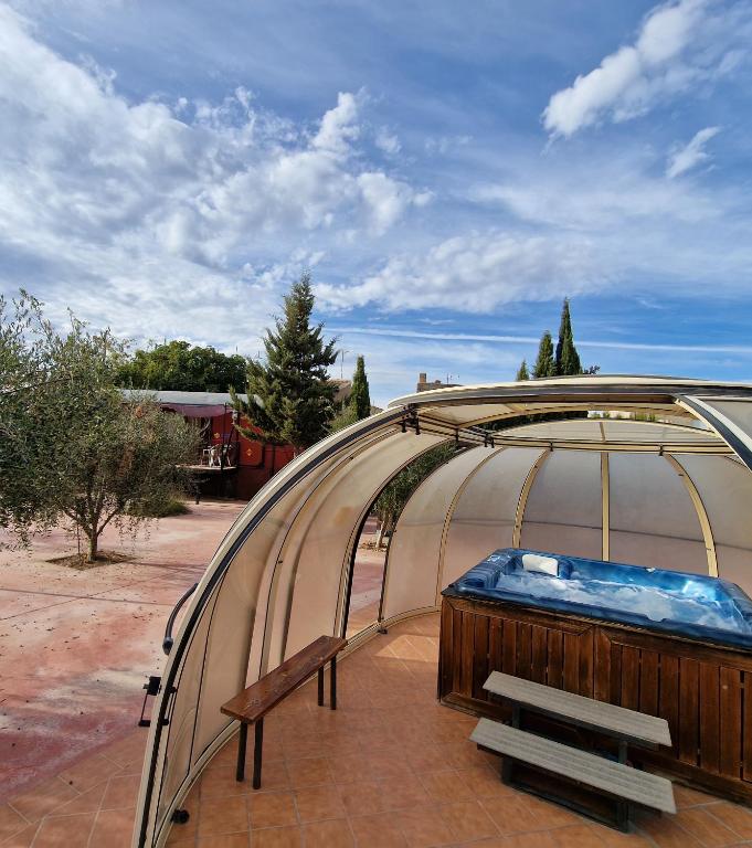 a greenhouse with a bench in front of it at Vagón con sesión de Jacuzzi in Caravaca de la Cruz