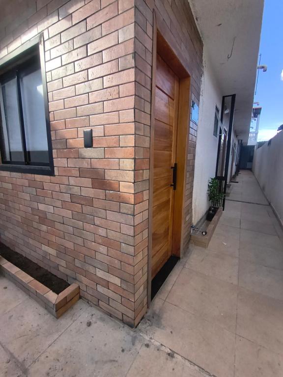a brick wall with a wooden door on a building at Lofts Sky Life in São José dos Campos