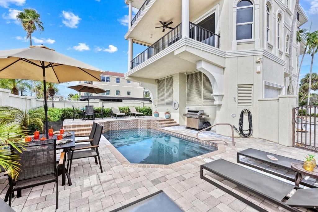 a patio with a pool and a table and chairs at Admirals Watch - 673 in Siesta Key