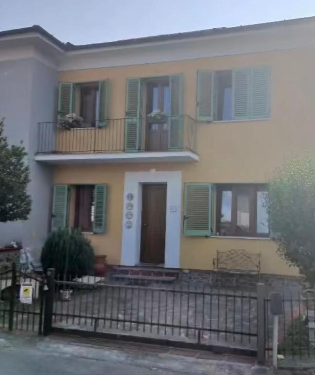 a house with green and white windows and a fence at Angela's House in Barga