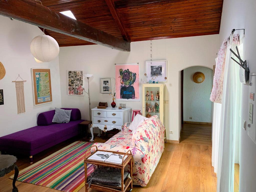 a living room with a purple couch and a table at Casa do Paço Aveiro - HolidayHome in Aveiro
