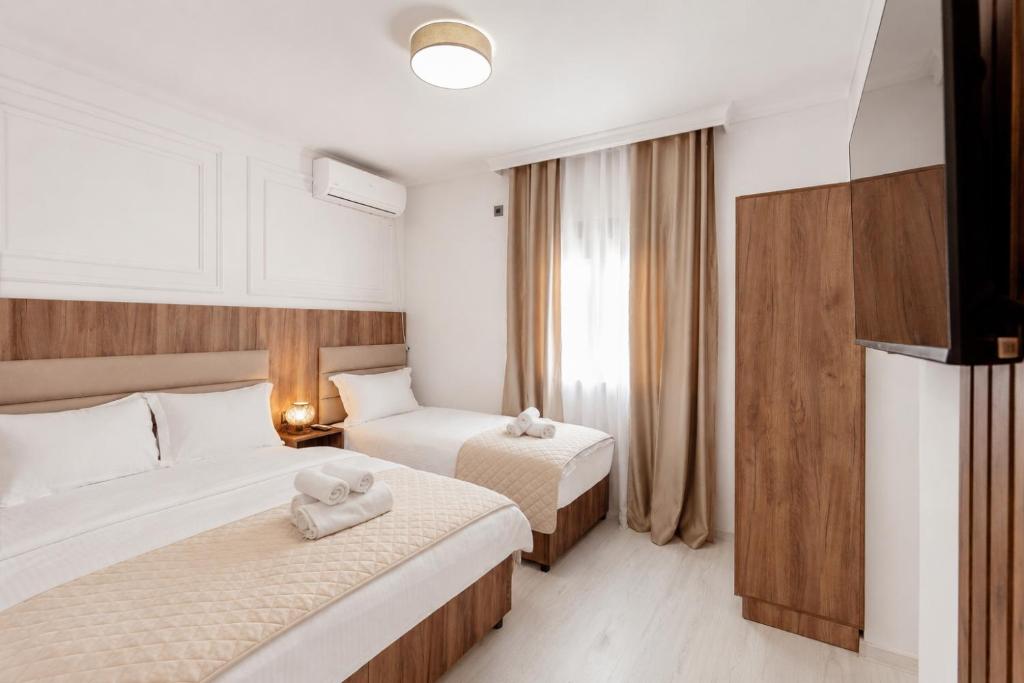 a hotel room with two beds and a window at Apartmani Centar in Igalo