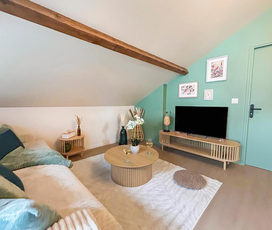 a living room with a couch and a tv at Élégant T3 moderne et central, parking inclus in Montargis