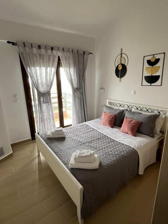 a bedroom with a large bed and a window at Angie Apartment in Ierissos