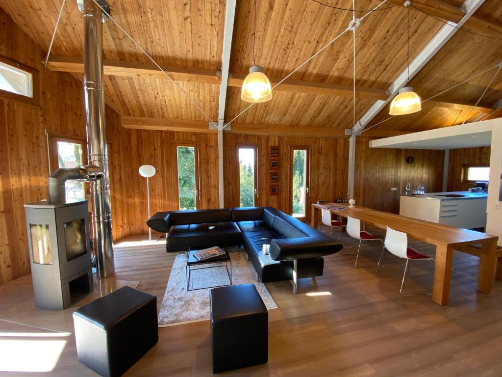 a living room with a black couch and a table at Sonnenchalet in Bodman-Ludwigshafen