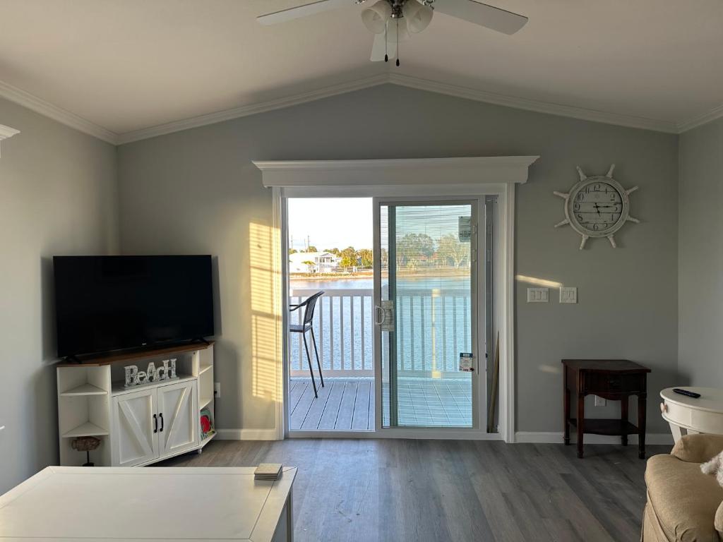 a living room with a tv and a sliding glass door at Lake Front, Beach Retreat in Fort Myers Beach