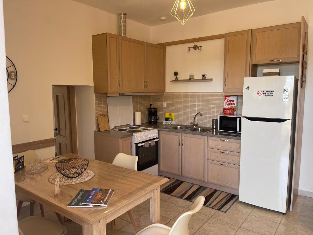 a kitchen with a table and a white refrigerator at Madou house in Leonidio