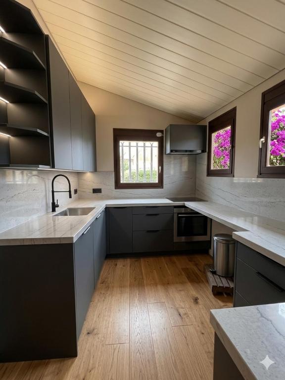 a large kitchen with white counters and a sink at Bienvenue au soleil in Sainte-Marie-la-Mer