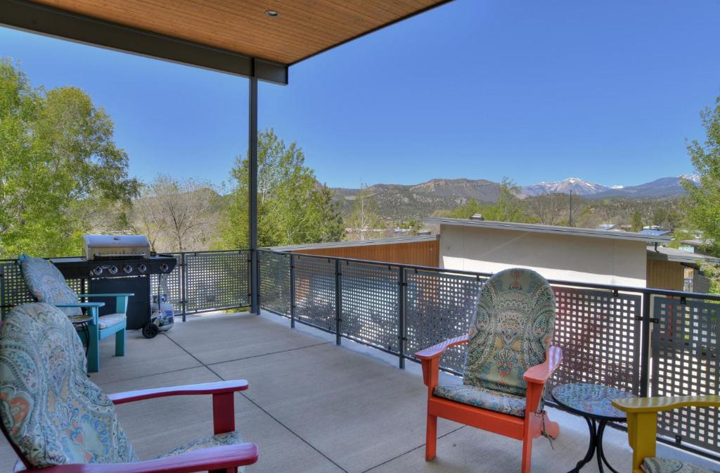 a balcony with two chairs and a table and a grill at 784 Florida in Durango