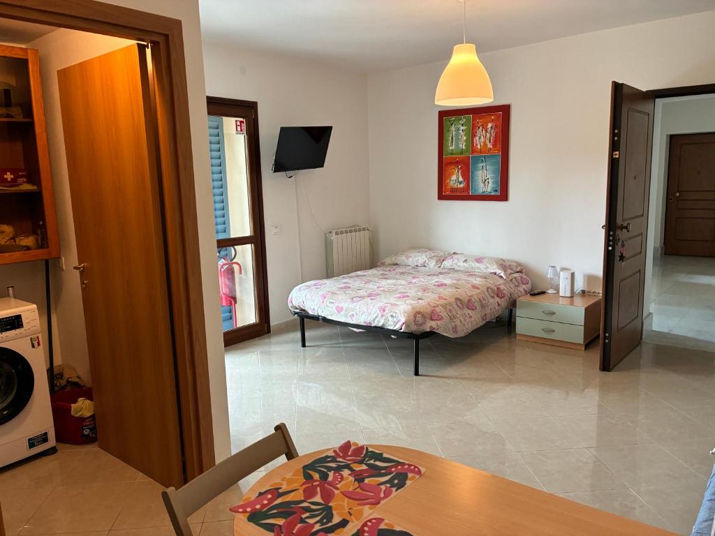 a bedroom with a bed and a table in a room at Le Persiane Azzurre ovest in Albiano