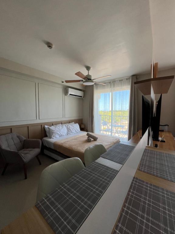 a bedroom with a bed and a couch and a tv at AR's Staycation in Lapu Lapu City