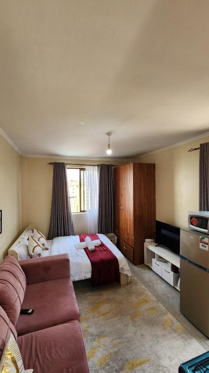 a bedroom with a bed and a couch in it at Ruaka Karington Studio in Ruaka