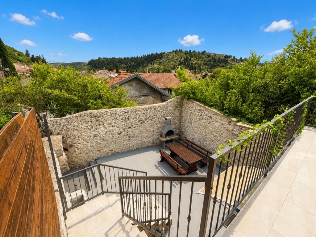 a balcony with a bench and a stone wall at Green House Cuprija in Stolac