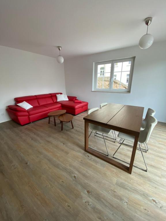 a living room with a red couch and a table at Apartment am Paradiespark in Jena