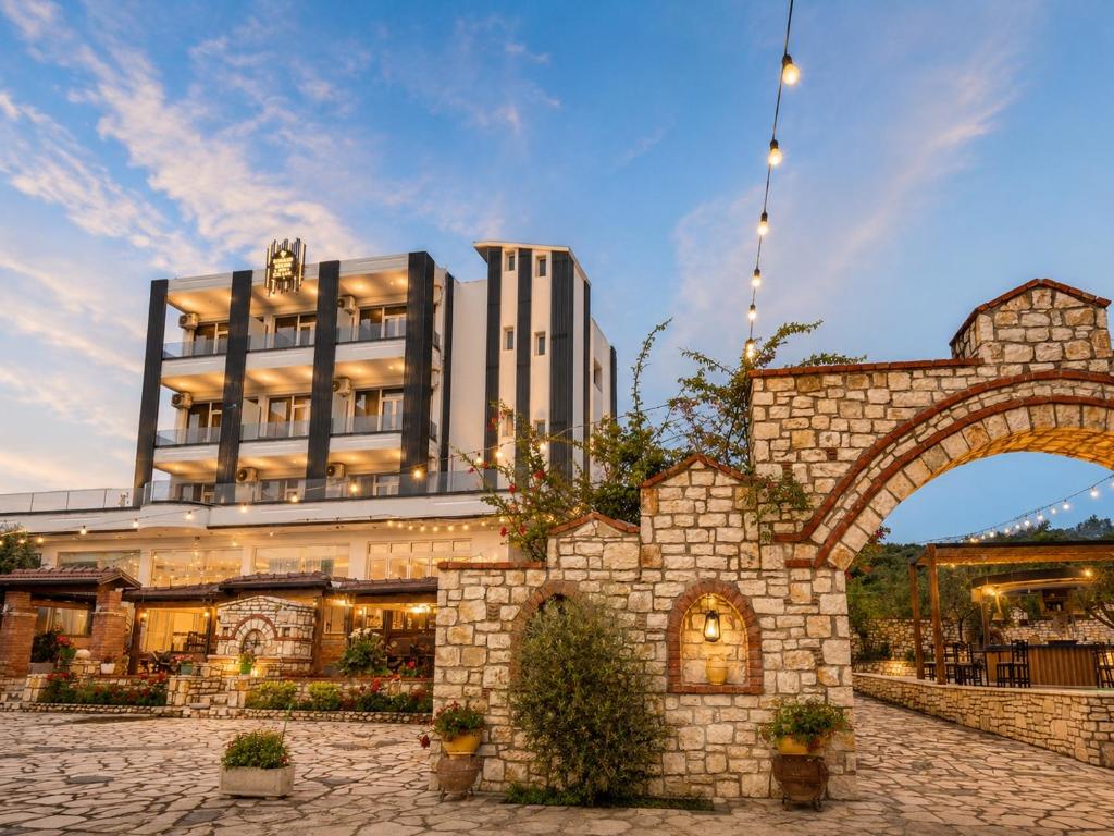 a building with an arch in front of it at Flogeri in Vlorë