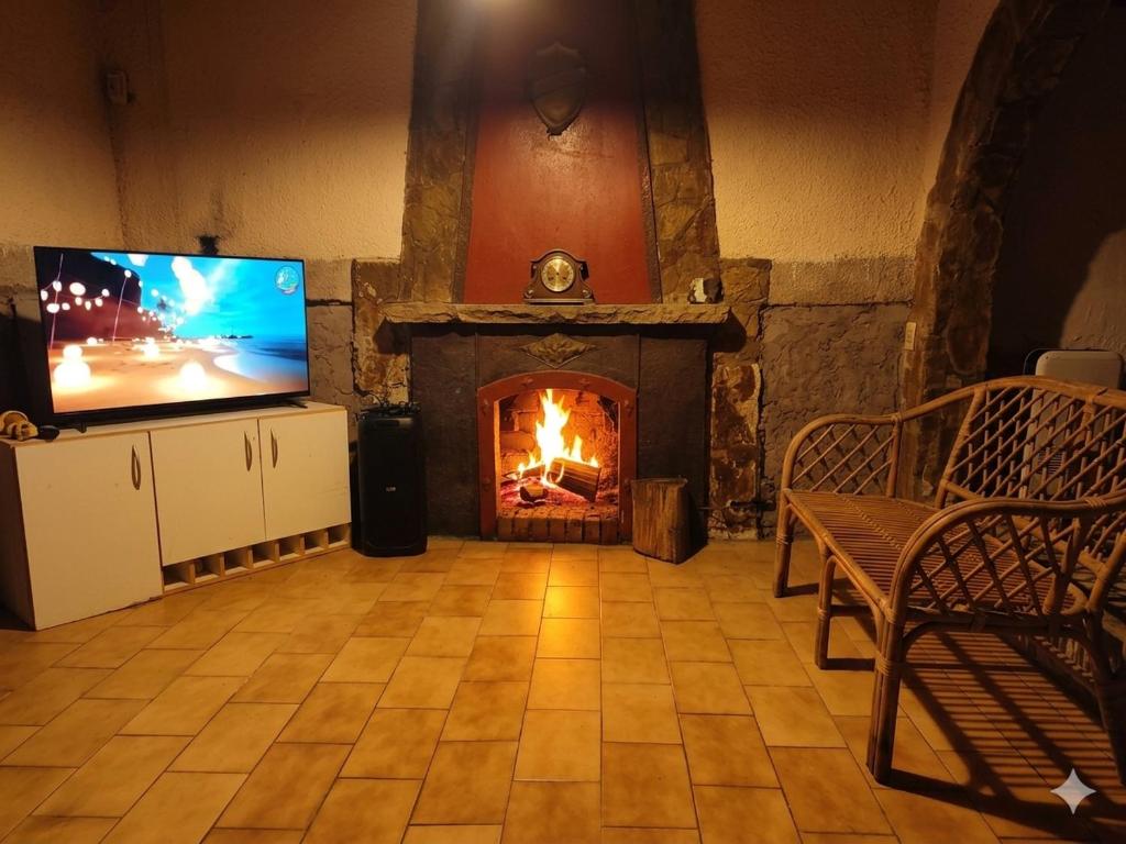 a living room with a fireplace and a television at Quinta Rancho Pingos in General Rodríguez