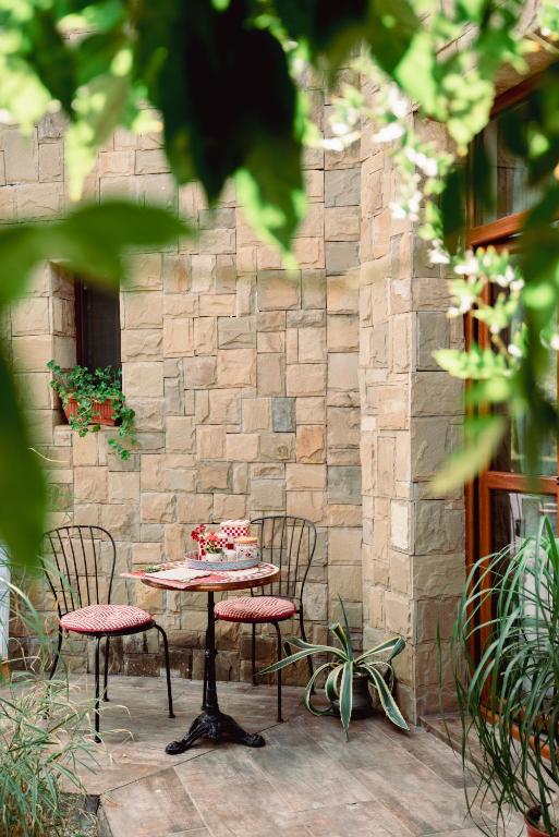 a table with two chairs and a table with a cake on it at Boomerang Guest House in Apriltsi