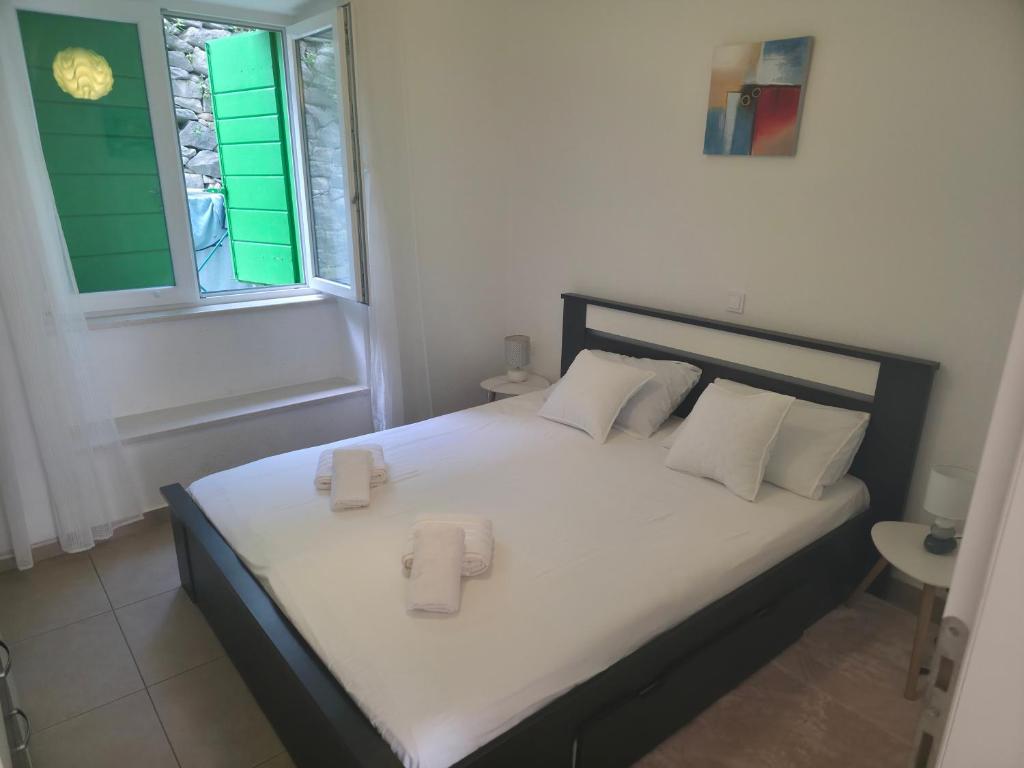 a bedroom with a bed with white sheets and a window at Apartman deluxe sea in Split