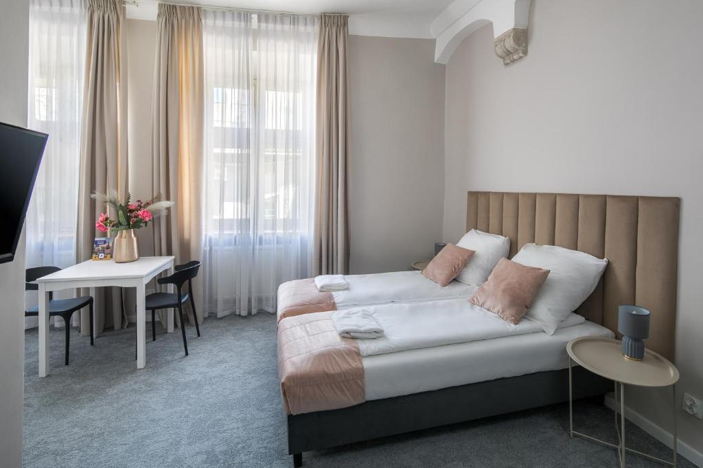 a hotel room with a bed and a table and a desk at Cracow Main Square Apartments in Krakow