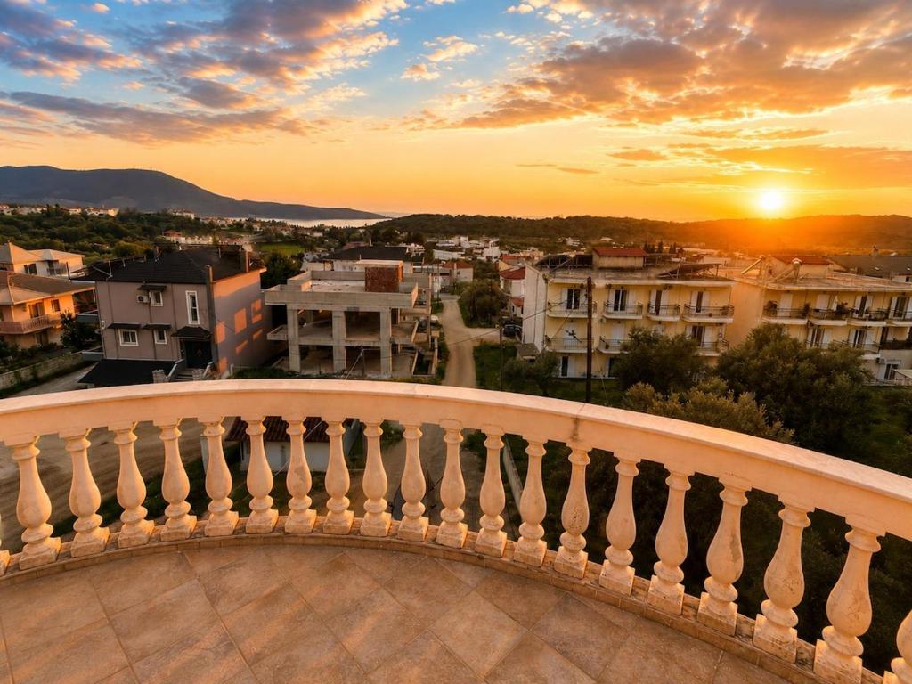 a view from a balcony of a city at sunset at Charming Apartment with Sea View in Néa Seléfkeia
