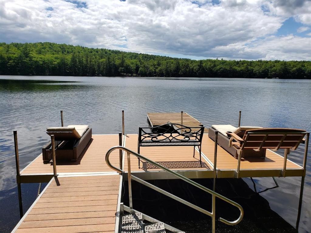 a dock on a lake with two chairs on it at HOLIDAY COVE - LIMIT 8 villa in Naples