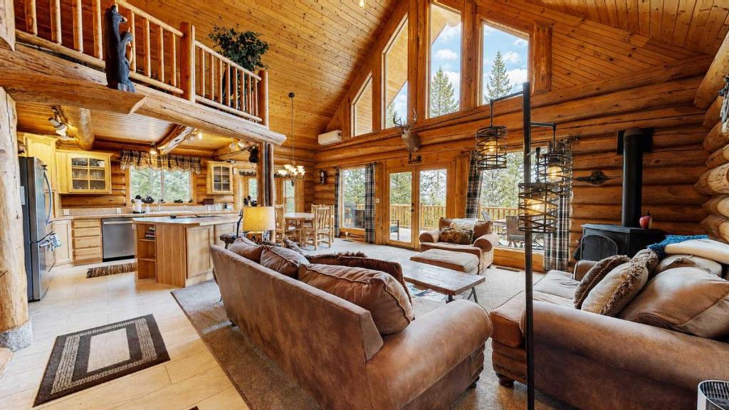 a living room with leather furniture in a log cabin at Cascade Lakeview Log Cabin in Cascade