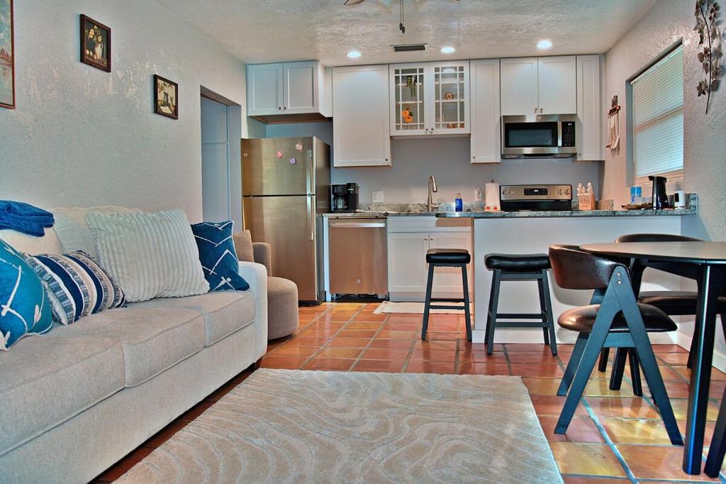 a living room with a couch and a table and a kitchen at Manatee River Bungalow - 4 in Bradenton