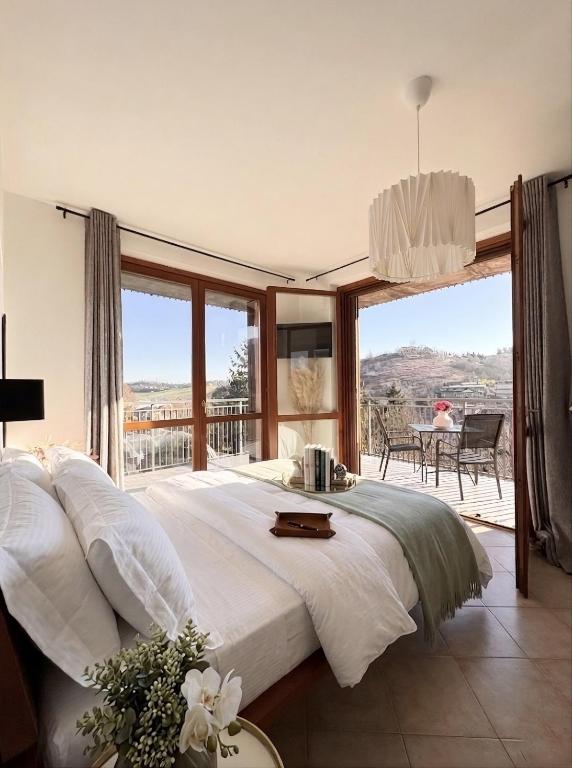 a large bedroom with a large bed and a balcony at Elegant Penthouse LA BALCONATA - Wellness Retreat & Castle View in Tabiano