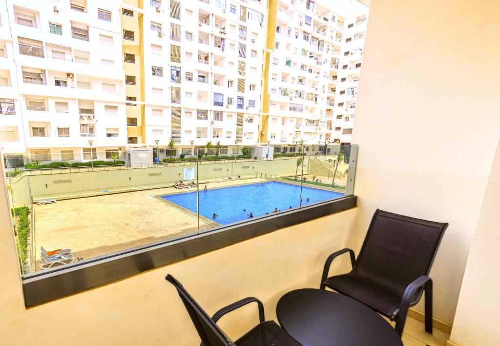 a waiting room with a pool and two chairs and a window at Grand Standing 110m2 Piscine Terrasse Proche Plage in Agadir