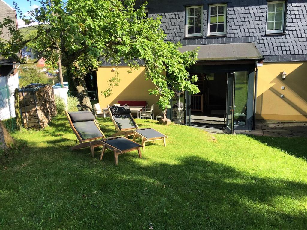 two chairs and a table in the yard of a house at Apfeltraum-Erzgebirge in Neuhausen